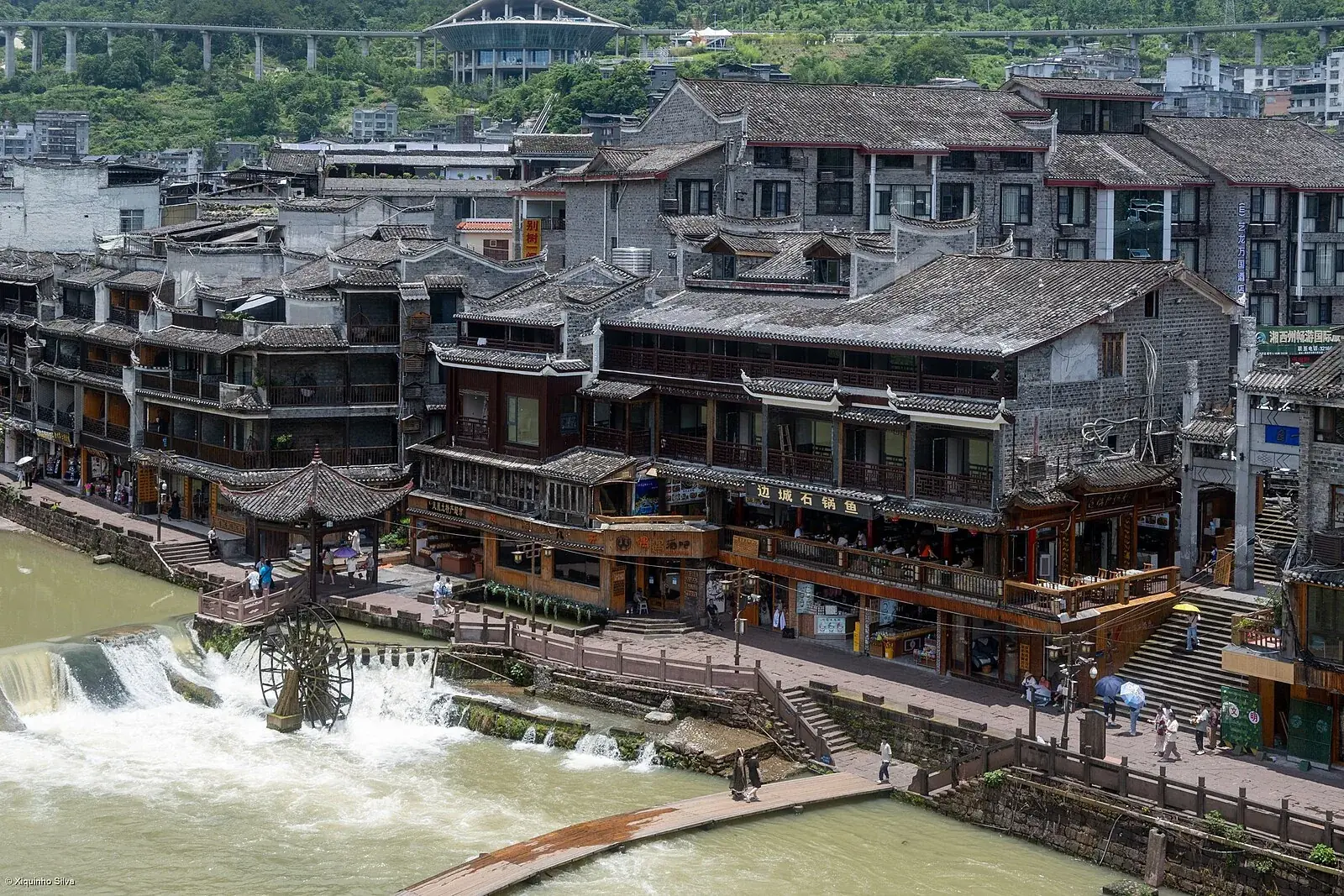 Roofs, riverfront buildings and a waterwheel beside the Tuojiang in Fenghuang.