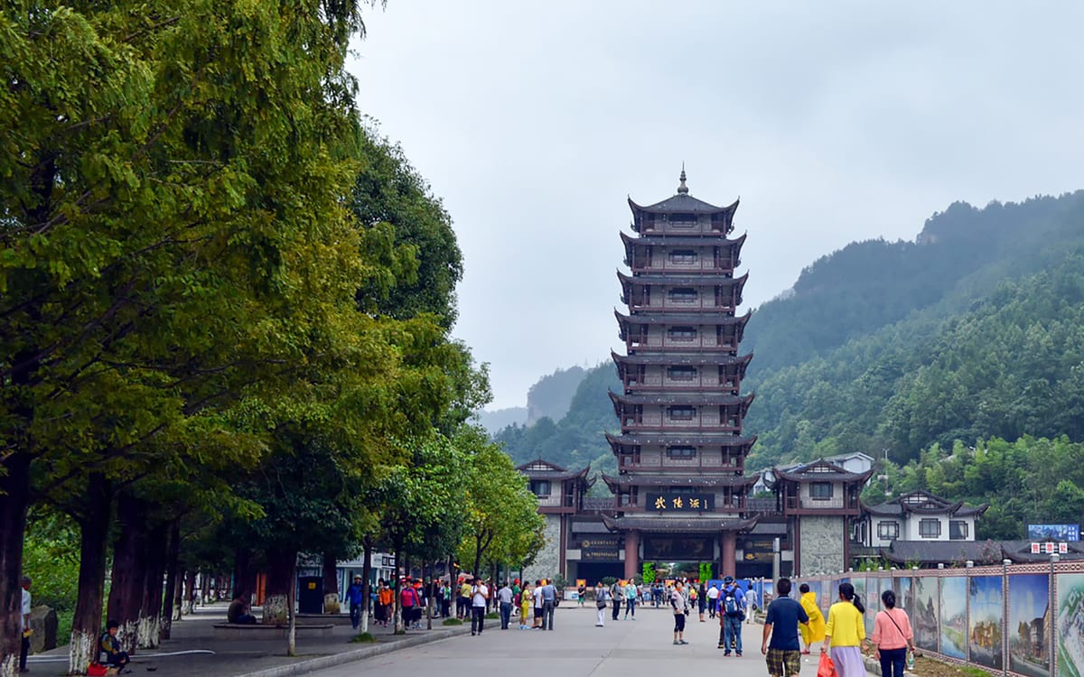 Visitors walking toward the Wulingyuan park gateway in Zhangjiajie on an overcast morning.