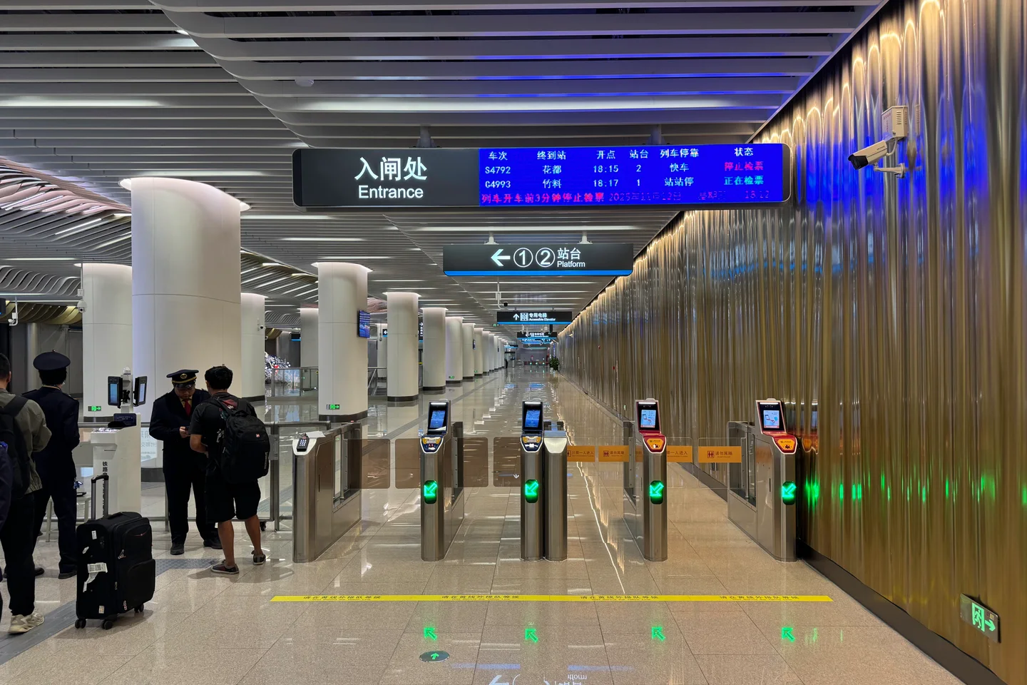 Entry gates and platform signs inside Baiyun Airport East intercity station at Guangzhou Baiyun Airport Terminal 3.