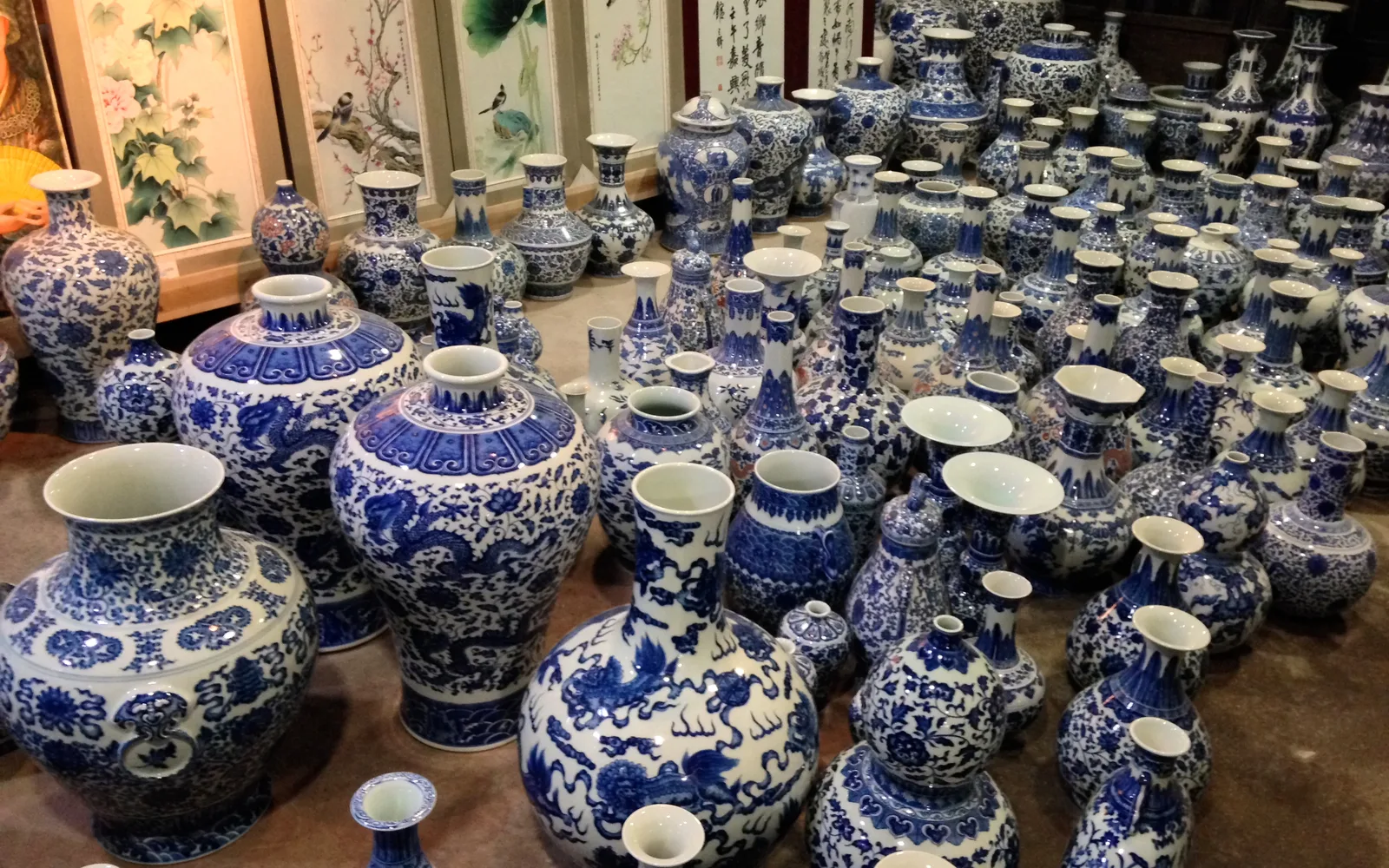 Dozens of blue-and-white porcelain vases and jars of different sizes set out for sale in Jingdezhen