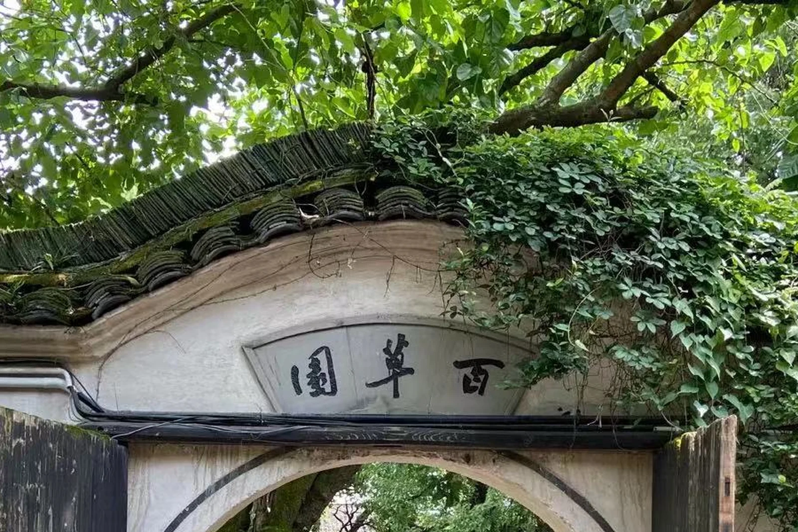 Gateway marked Baicao Garden within the Lu Xun former-residence visitor group in Shaoxing.
