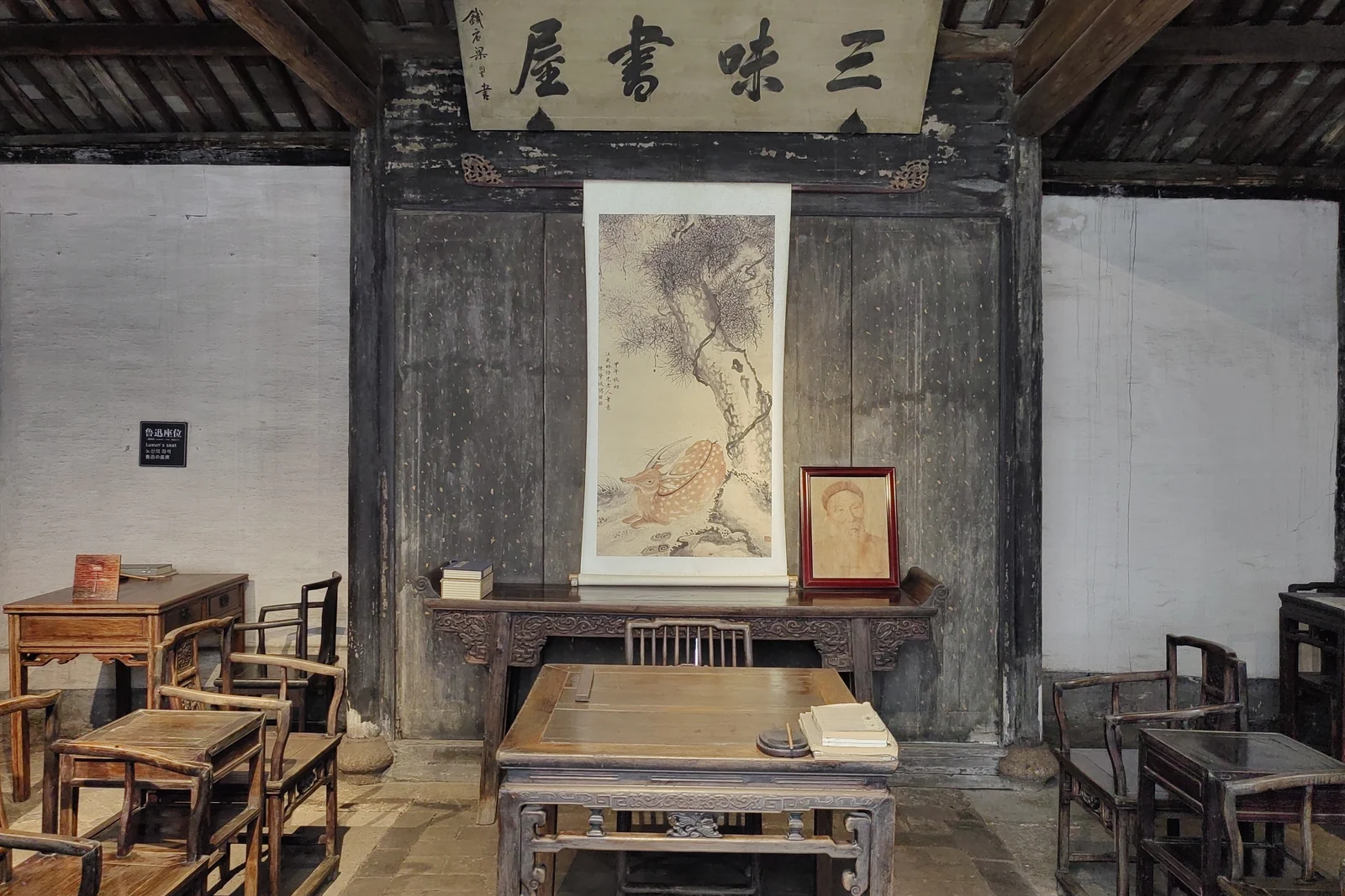 Interior of Sanwei Study with desks, nameboard and the museum label identifying Lu Xun's seat.