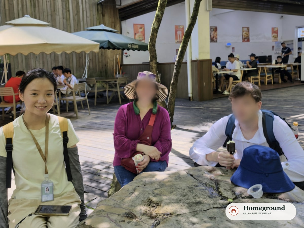 Tantan accompanying two international guests during a local visit; guest faces are blurred for privacy.