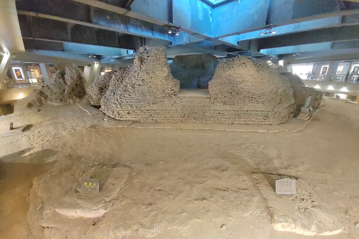 Old brick remains of Leifeng Pagoda are protected inside the present visitor building.