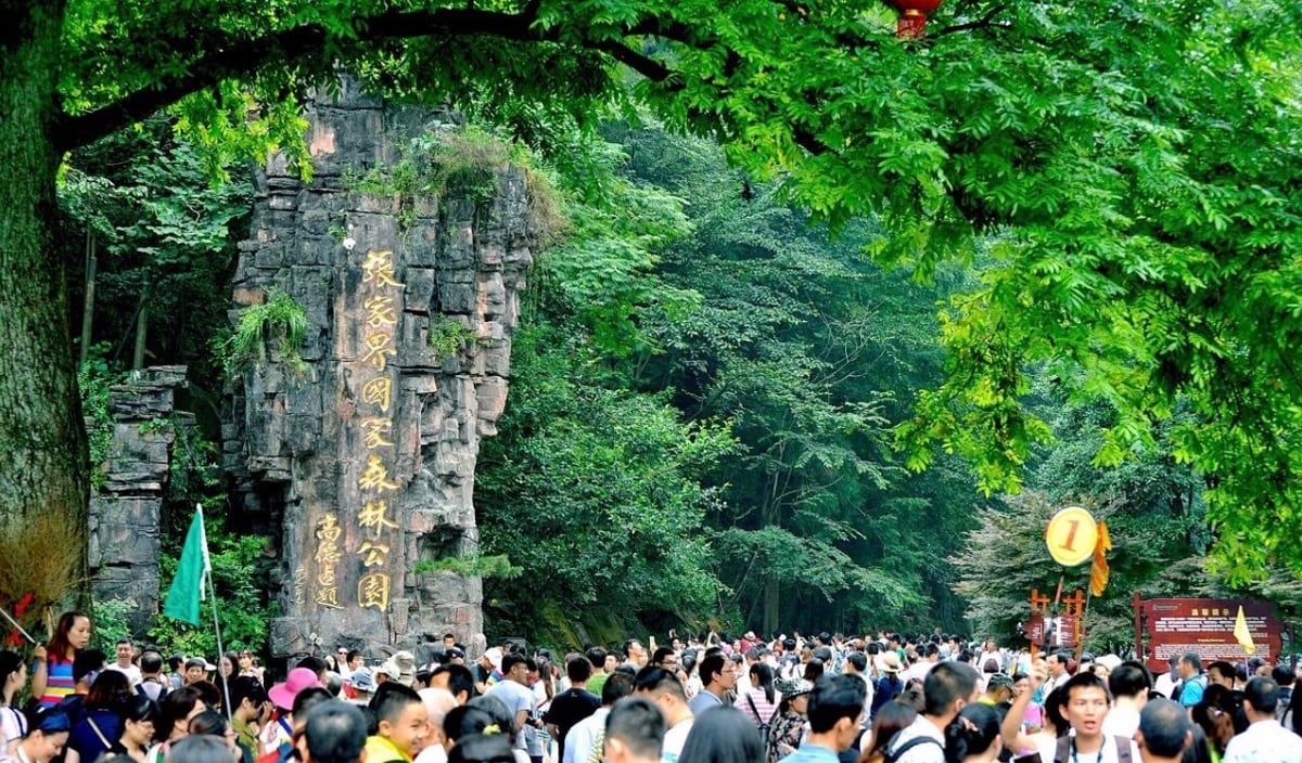 旅客聚集在张家界国家森林公园一处绿树浓密的入口。