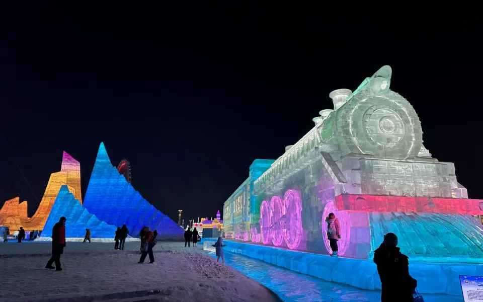 A colourful ice train and illuminated ice buildings at Harbin Ice and Snow World in 2026