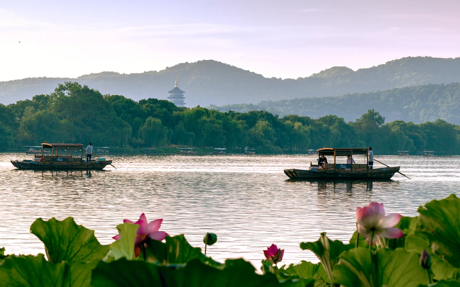 Boats on West Lake in Hangzhou with lotus in the foreground