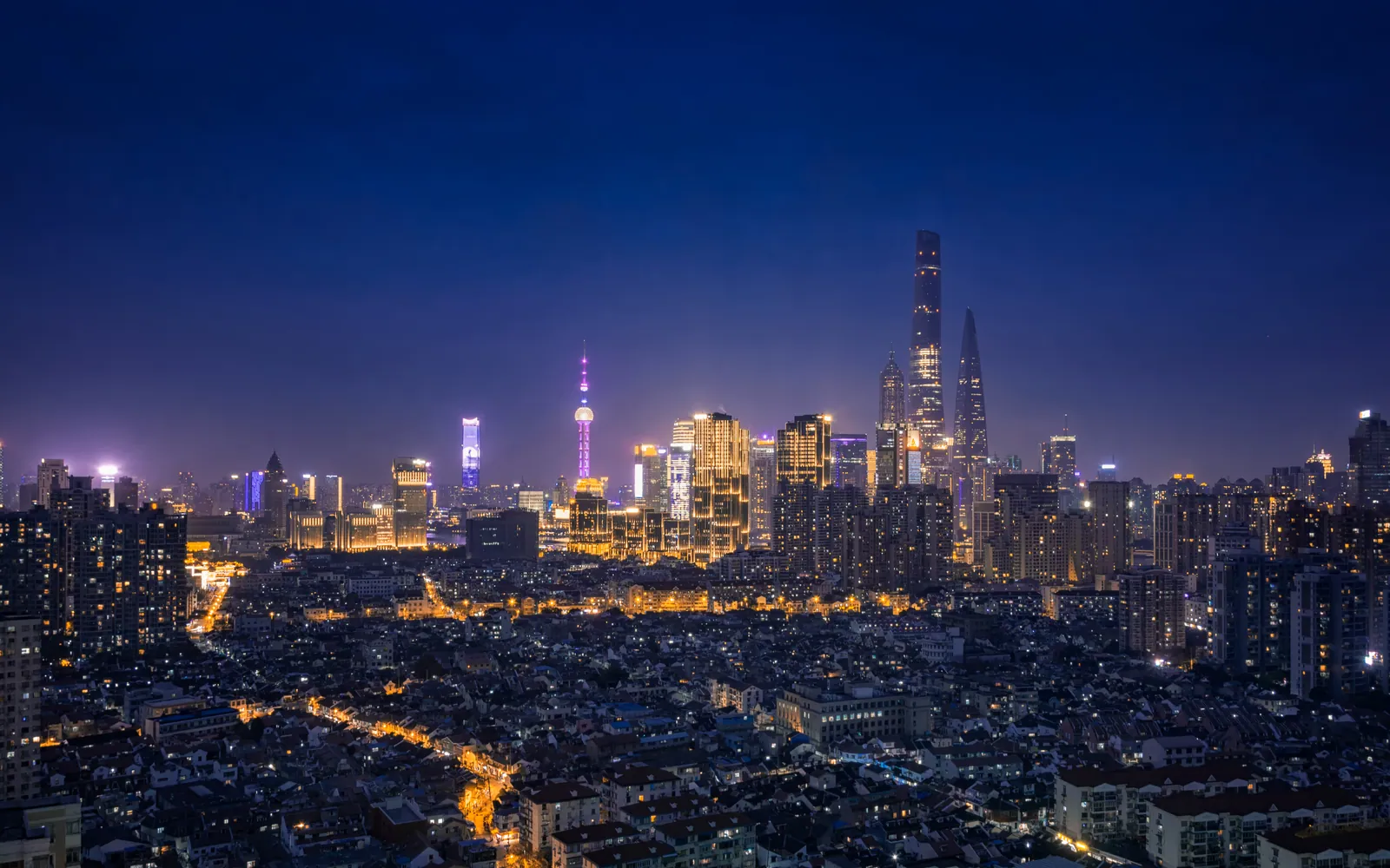 Old Shanghai rooftops with the Lujiazui towers lit behind