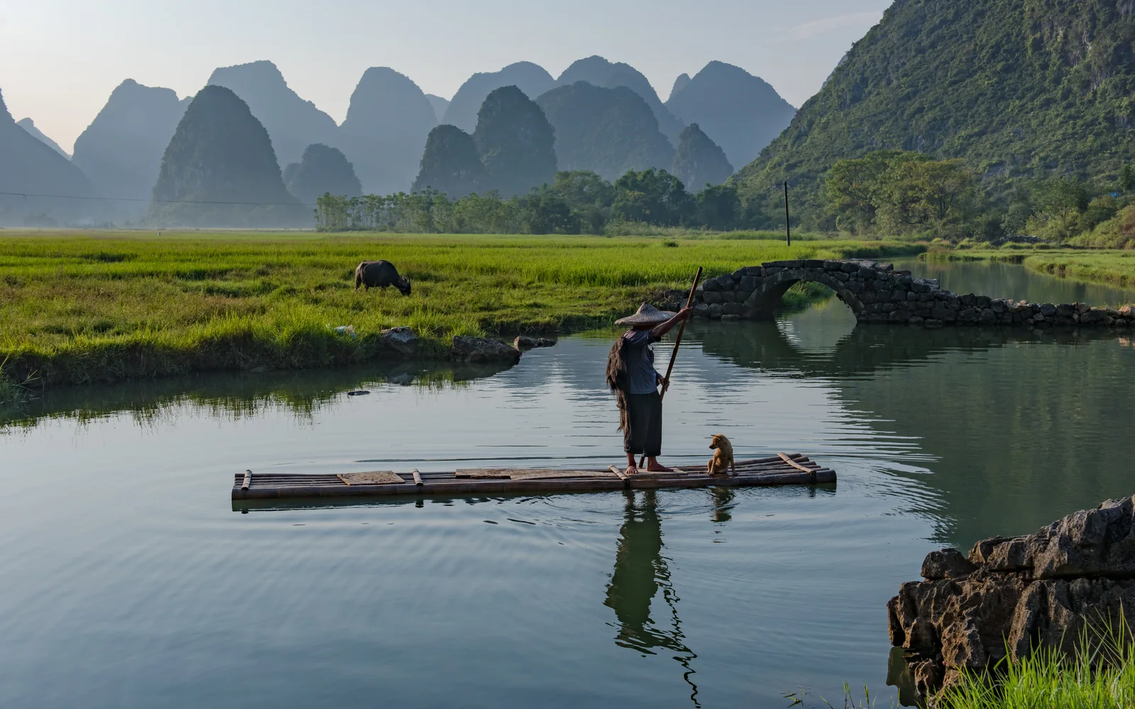 A bamboo raft and fields beneath Yangshuo's karst hills
