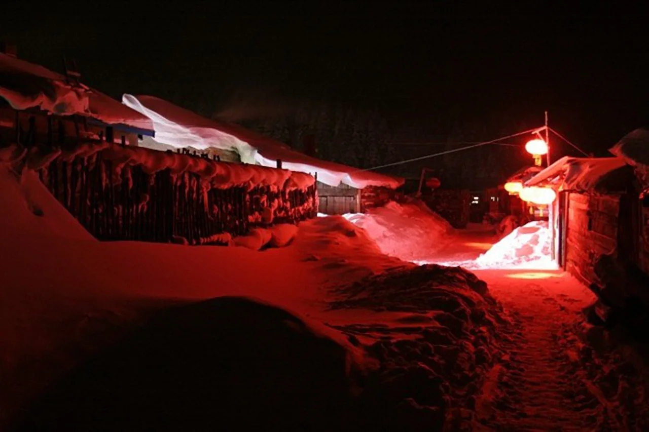 Red-lit snowy street in Beiji Village at night