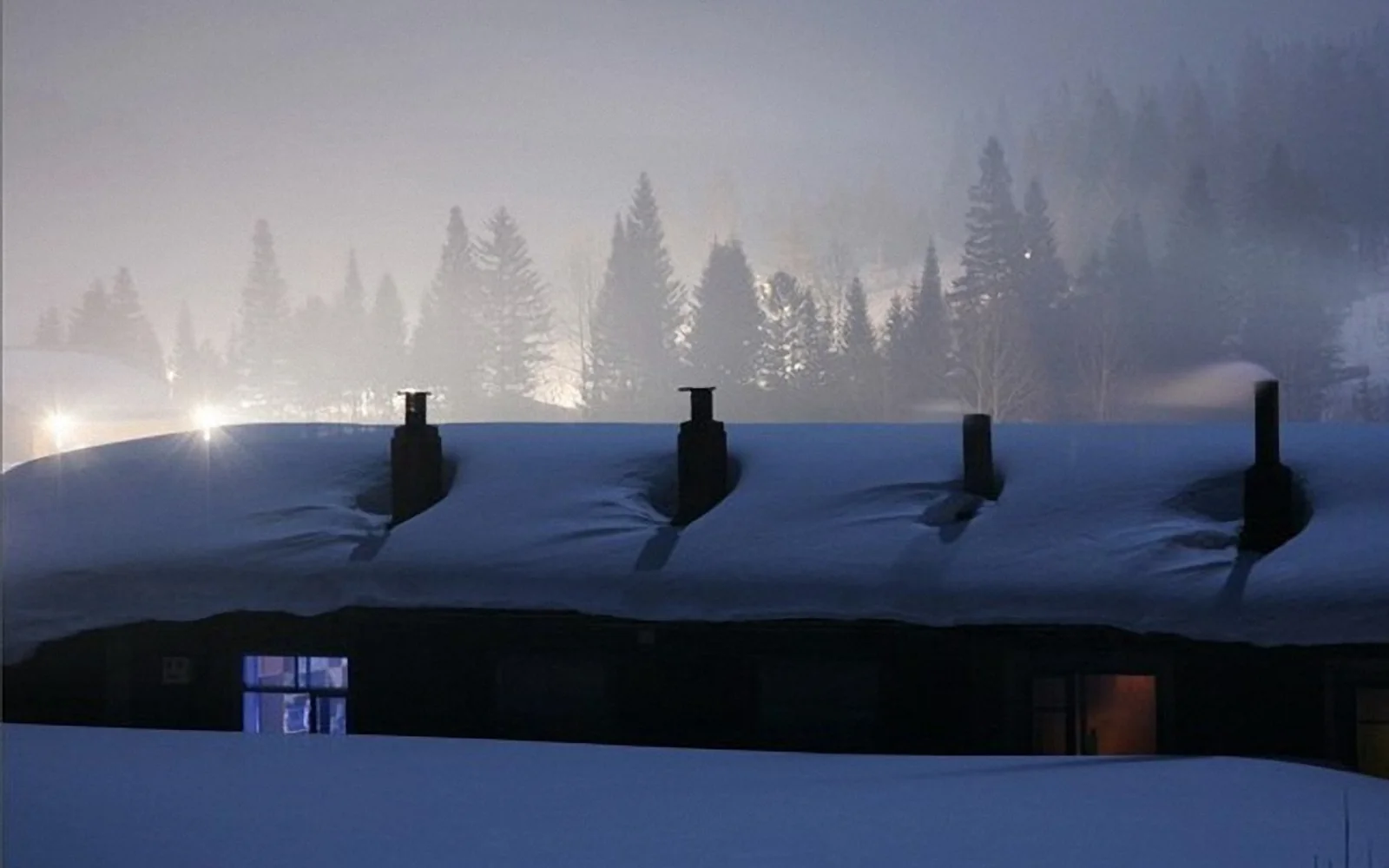 A snow-covered wooden house at night in Beiji Village, Mohe