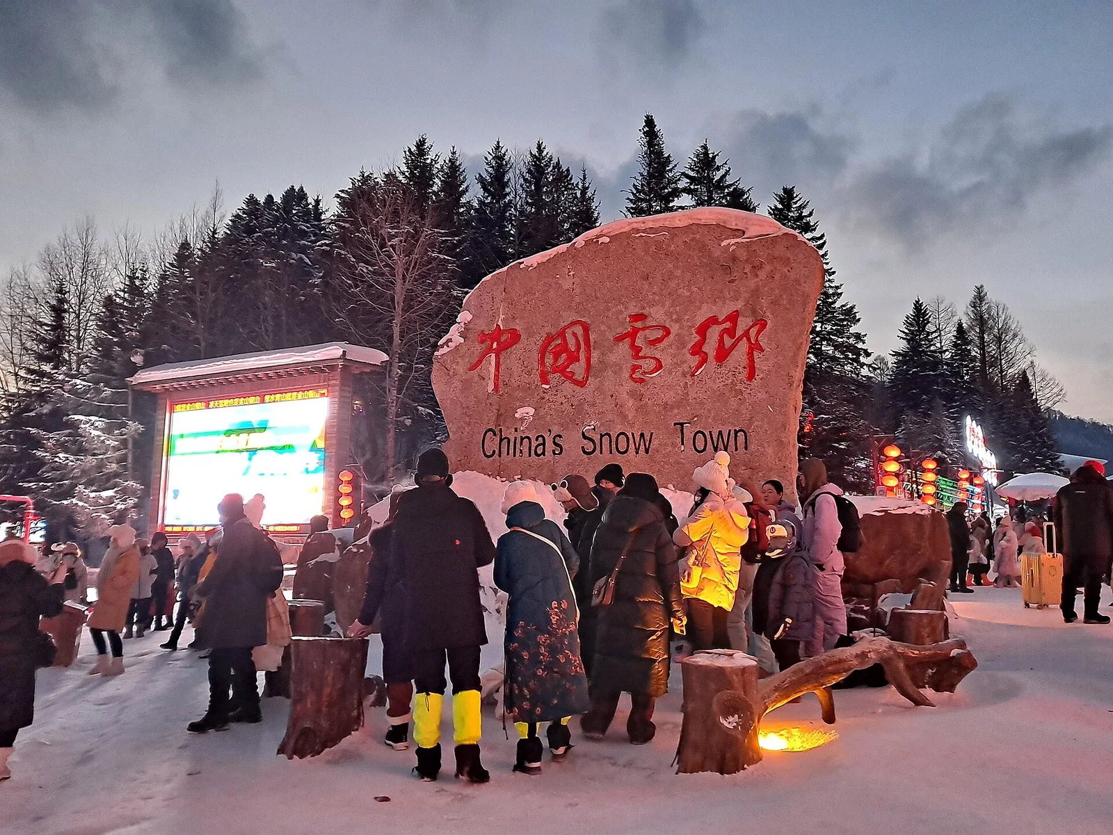 Visitors beside the China Snow Town entrance marker in winter