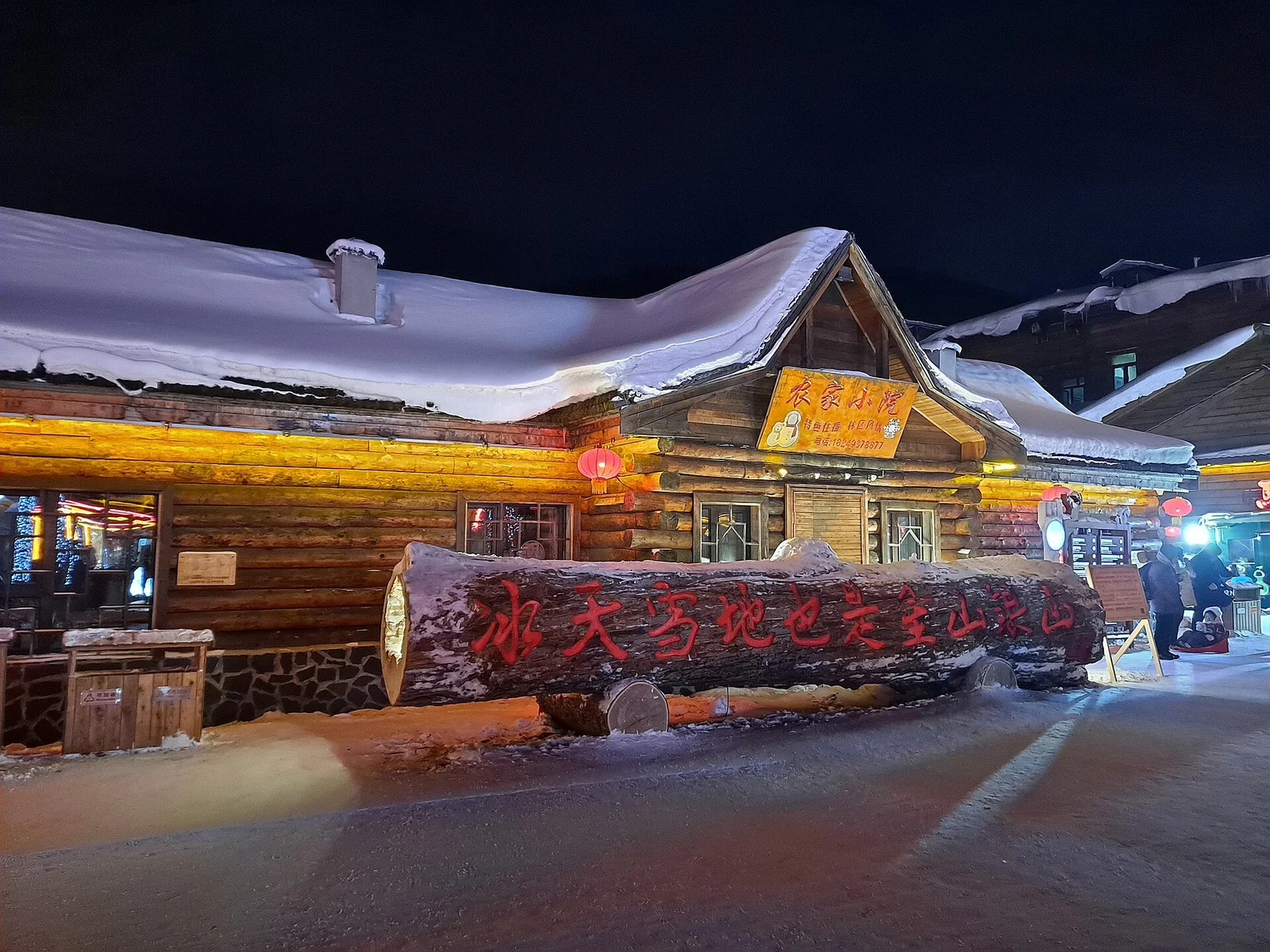Snow-covered wooden buildings at night in China Snow Town