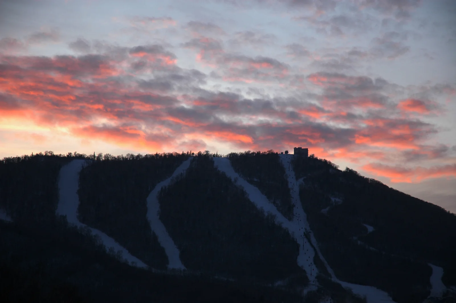 Red sunset above snowy ski runs at Yabuli Sun Mountain