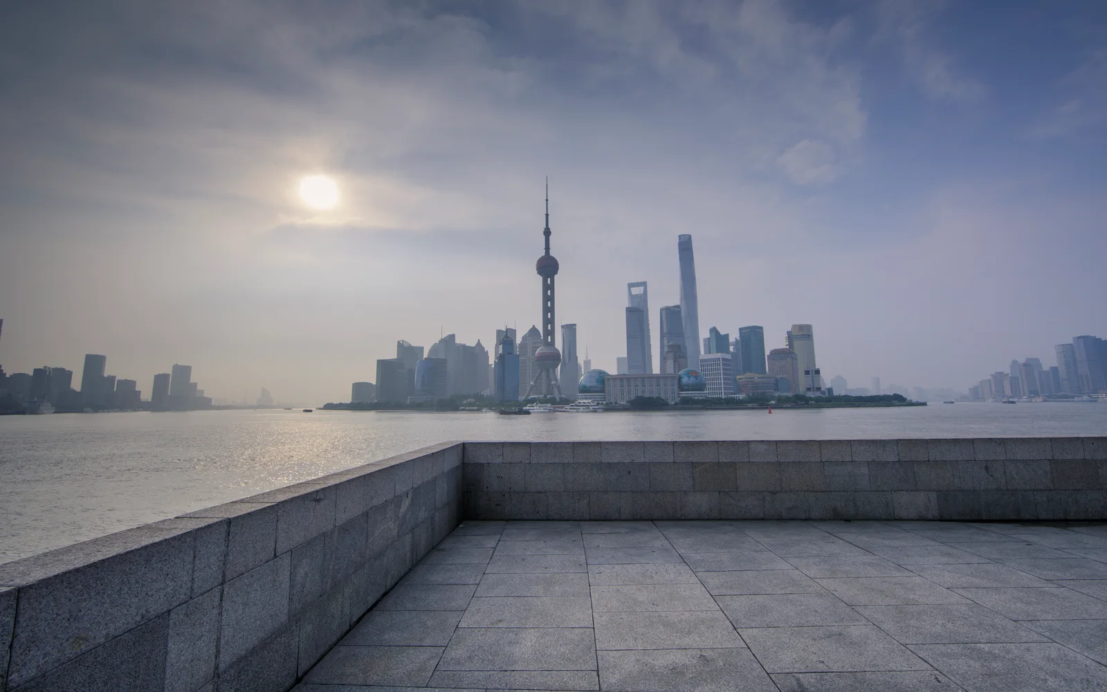 A quiet riverfront platform facing Shanghai's skyline