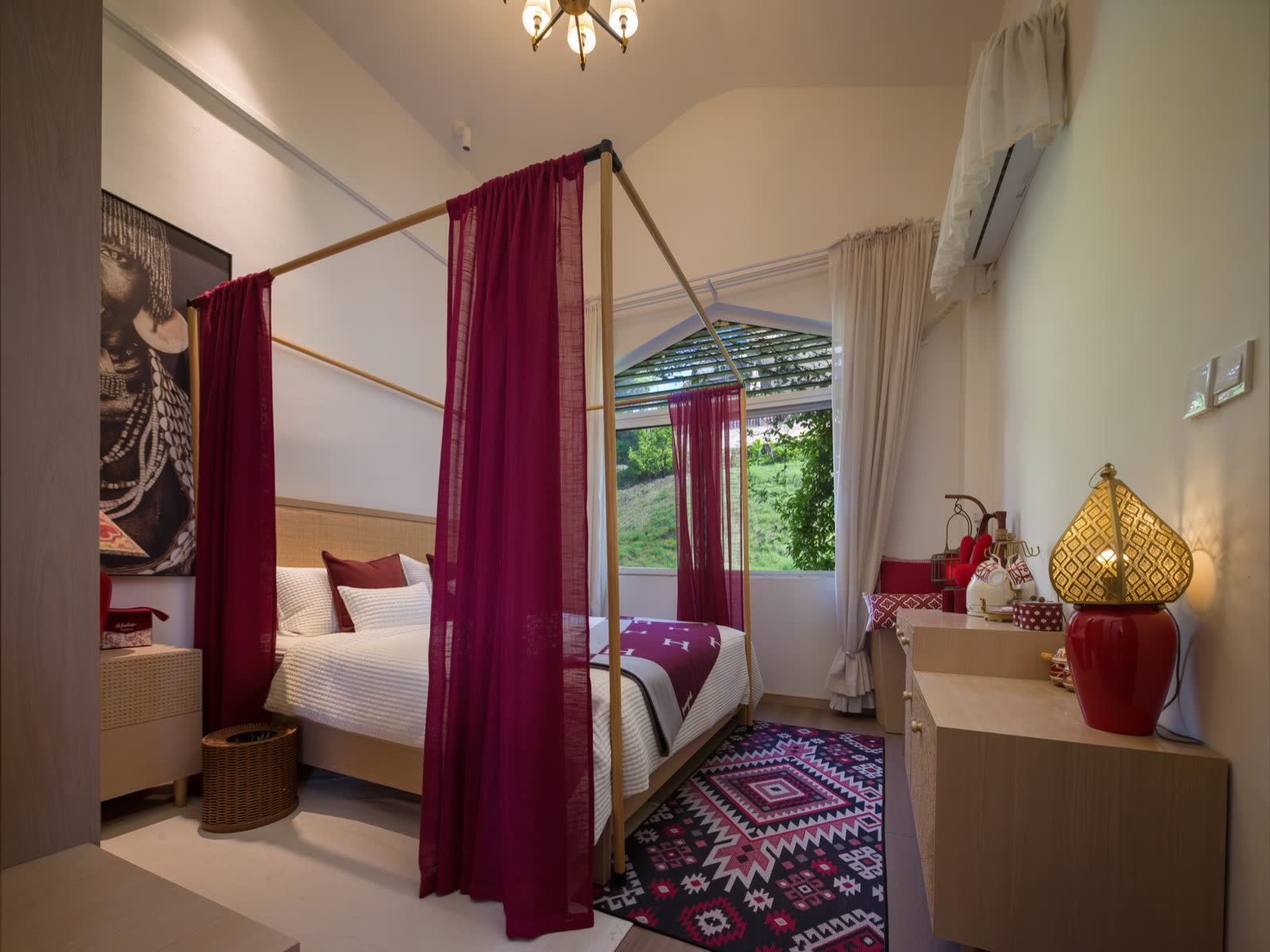 Guest room with a four-poster bed, deep-red drapes and patterned textiles